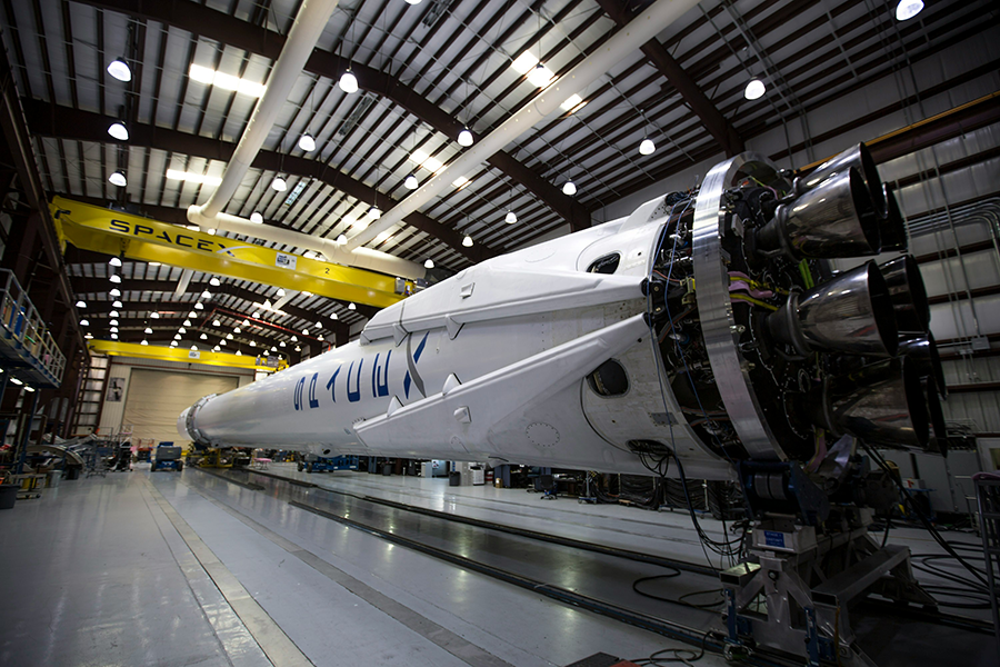 A SpaceX rocket sits inside a hangar.