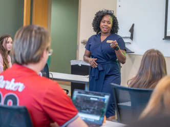 A professor teaching a room full of college students.