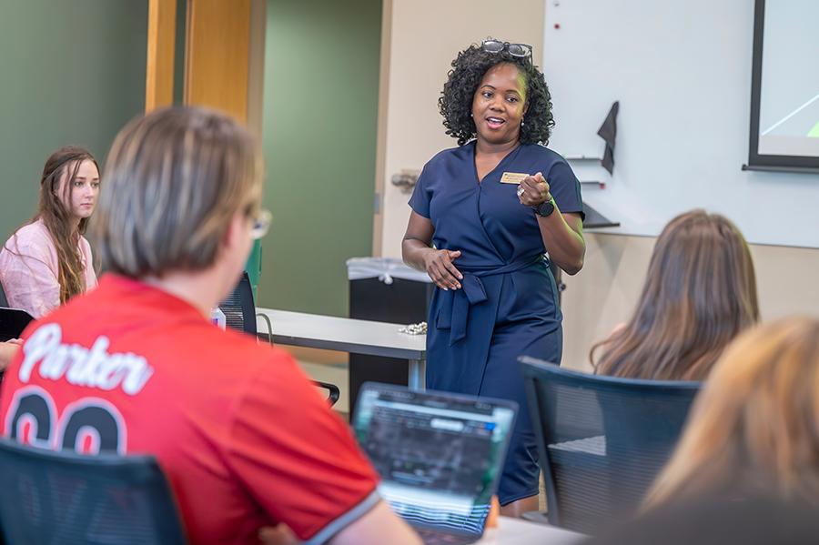 A professor teaching a room full of college students.