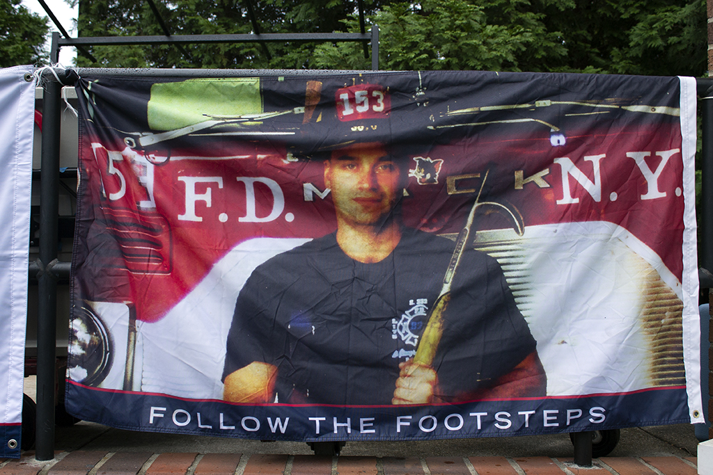 Banner with a picture of a New York firefighter in front of a fire truck with the number 153 on his hat. The words "Follow the footsteps" are along the bottom of the banner.