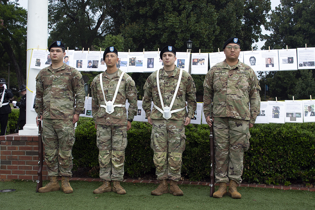 Four men wearing uniforms standing at attention.