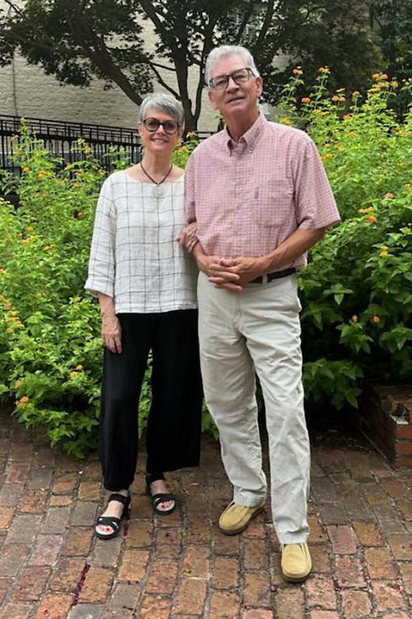 Older couple standing side-by-side outside.