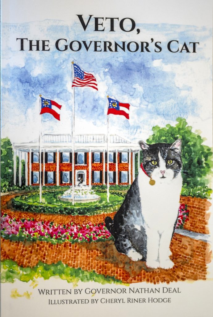 Book cover for "Veto, the governor's cat," showing a cat sitting outside a governor's mansion.