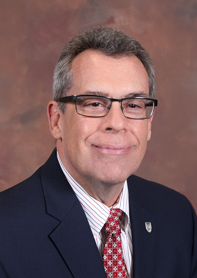 Man wearing glasses and a suit and tie.