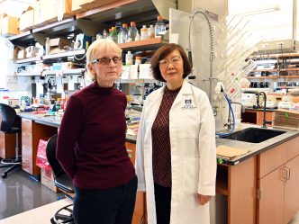 Two female researchers stand in a lab.