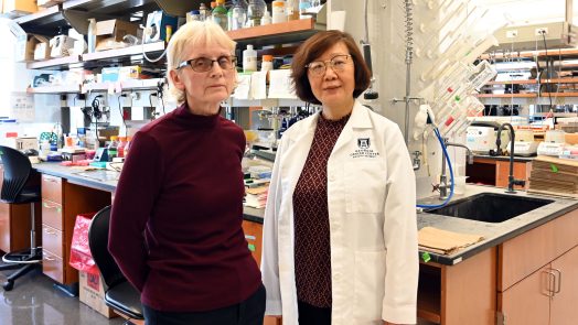 Two female researchers stand in a lab.