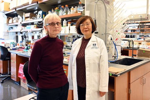 Two female researchers stand in a lab.