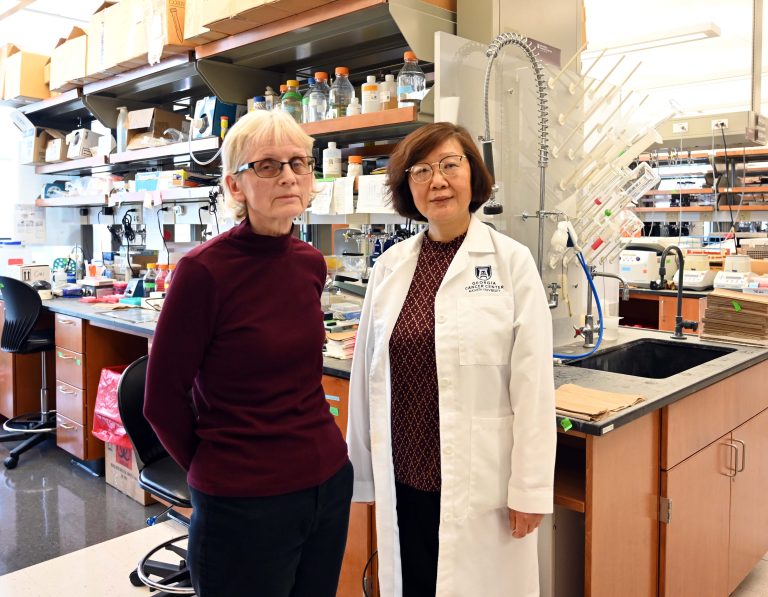 Two female researchers stand in a lab.