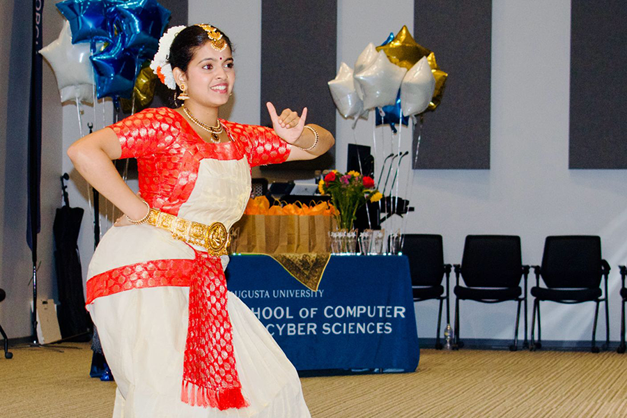 A woman dressed in traditional Indian clothing performs a dance.