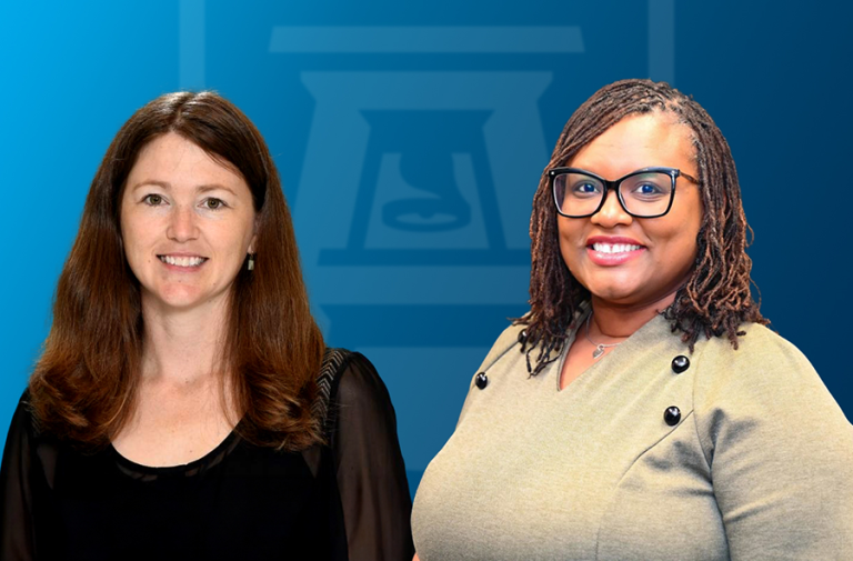 Two women stand side-by-side and smile. There is a logo for Augusta University featuring an AU and bell tower behind them.