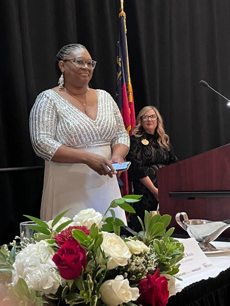 A woman stands behind a podium and accepts an award.