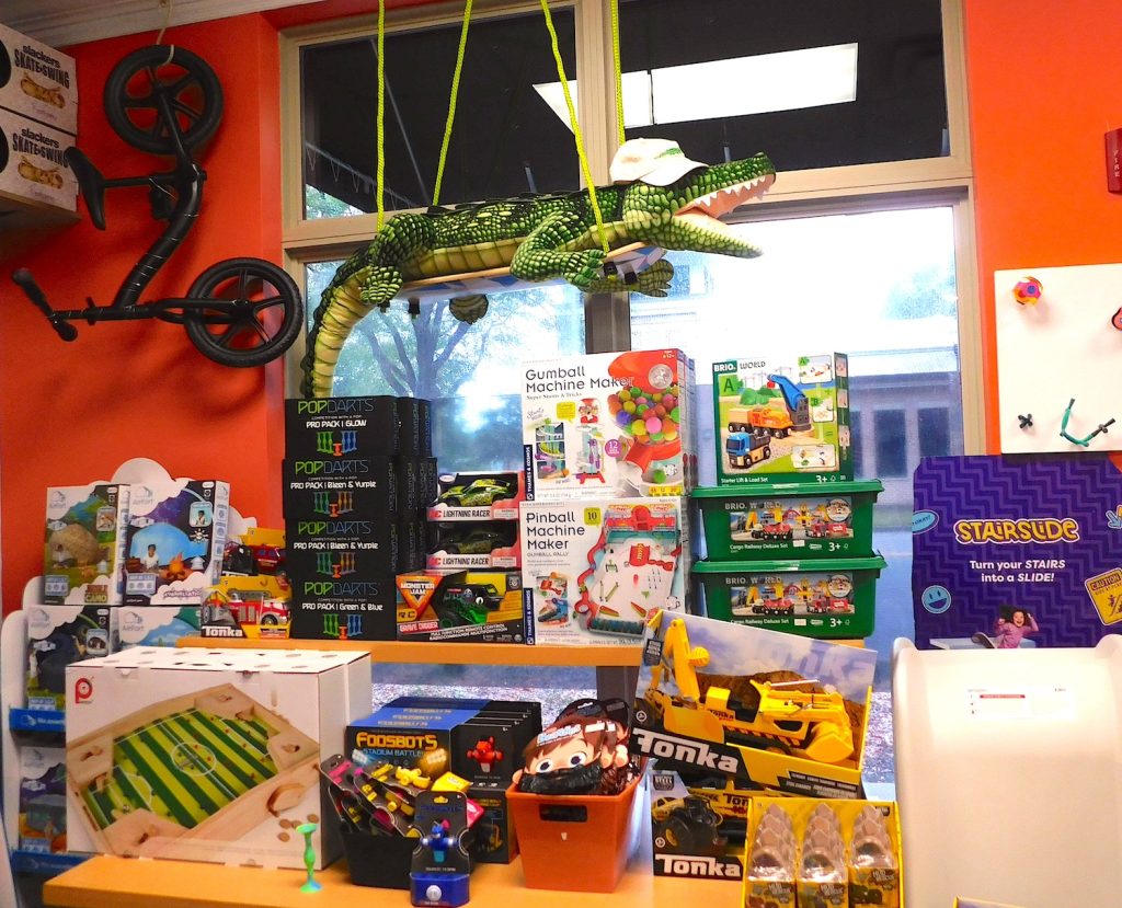 A small-business toy store with toys in a large window.