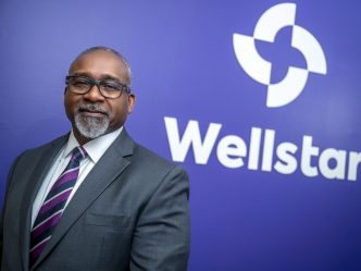 Man standing in front of a sign for Wellstar MCG Health.