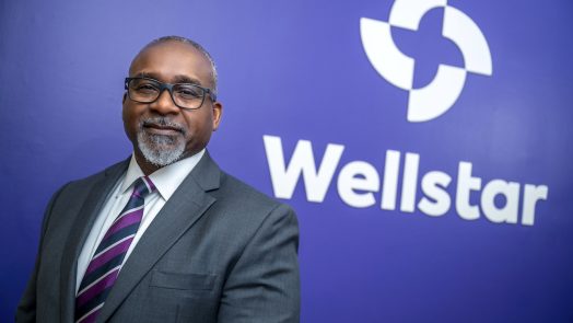 Man standing in front of a sign for Wellstar MCG Health.