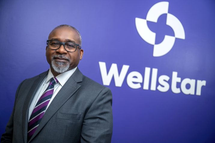 Man standing in front of a sign for Wellstar MCG Health.