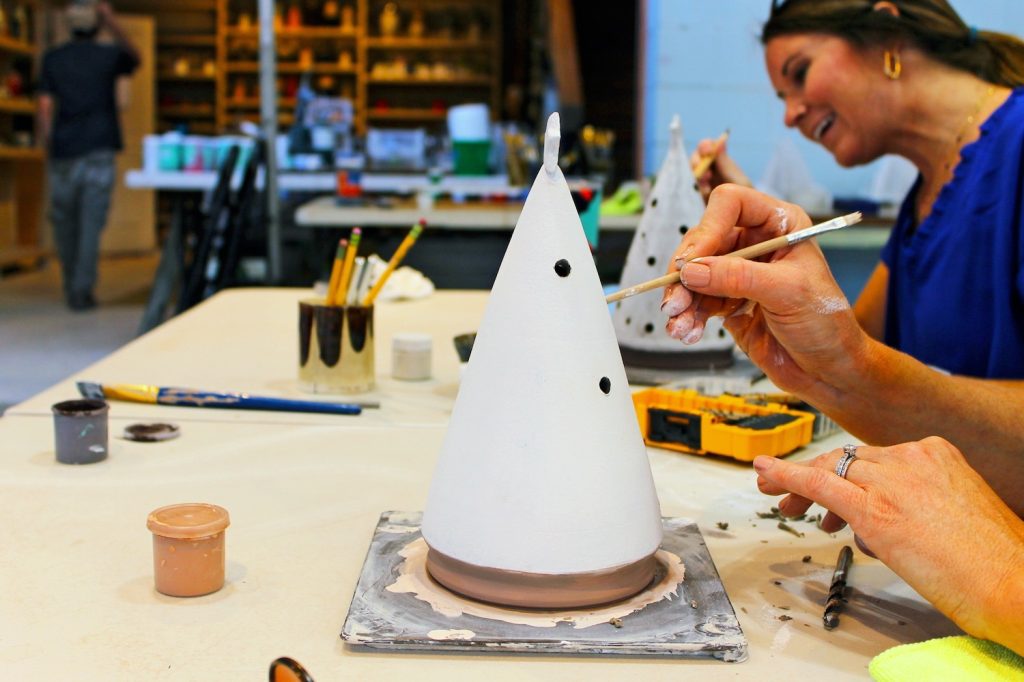 People painting ceramic Christmas trees.