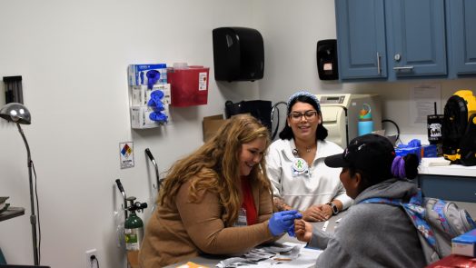 Volunteers perform blood work on a woman in a clinic.