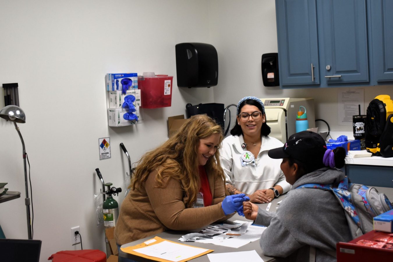 Volunteers perform blood work on a woman in a clinic.