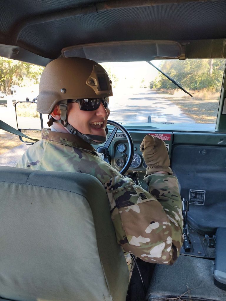 A man in uniform is behind the wheel of a vehicle. 