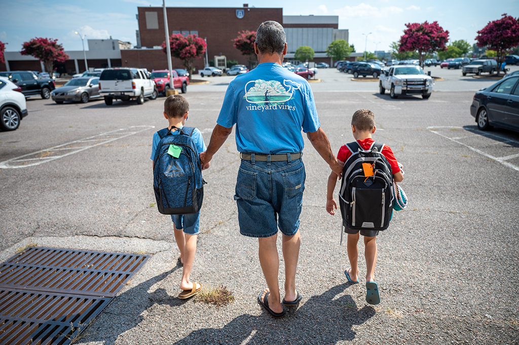 Man walking with two children with new backpacks