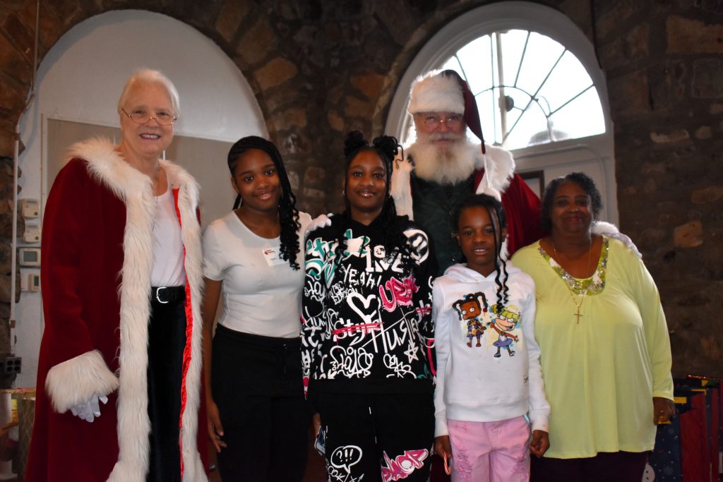 Three children and their grandmother meet Santa and Mrs. Claus.