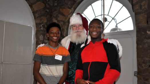 Two teenage boys pose with santa