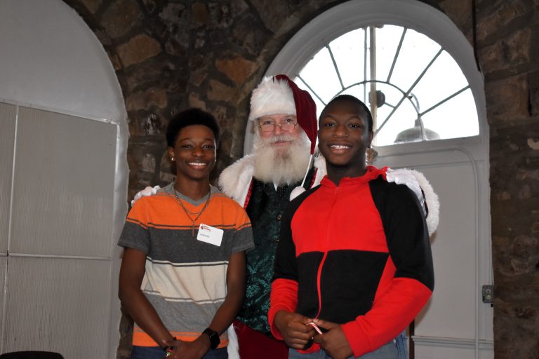 Two teenage boys pose with santa