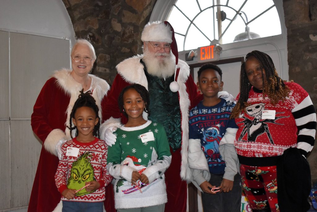 Three children and their grandmother meet Santa and Mrs. Claus.