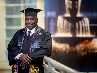 Man smiling in a cap and gown