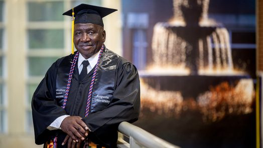 Man smiling in a cap and gown