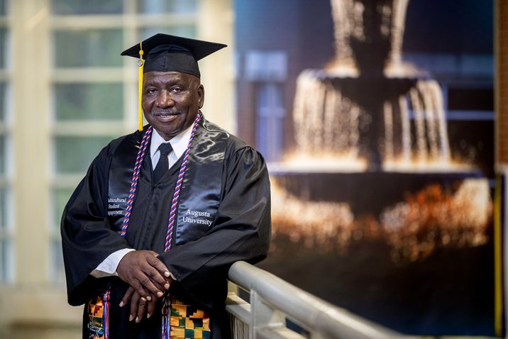 Man smiling in a cap and gown