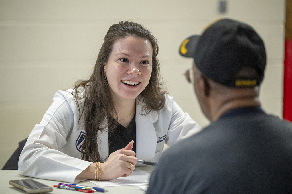 Female nursing student talking with a male patient