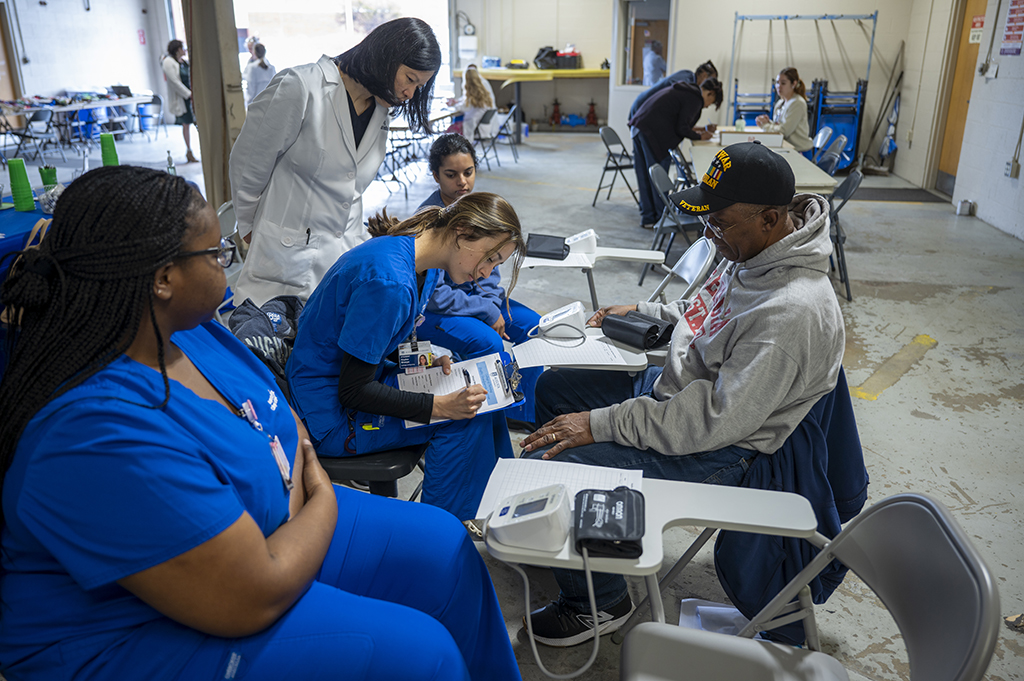 Female nursing students helping a male patient