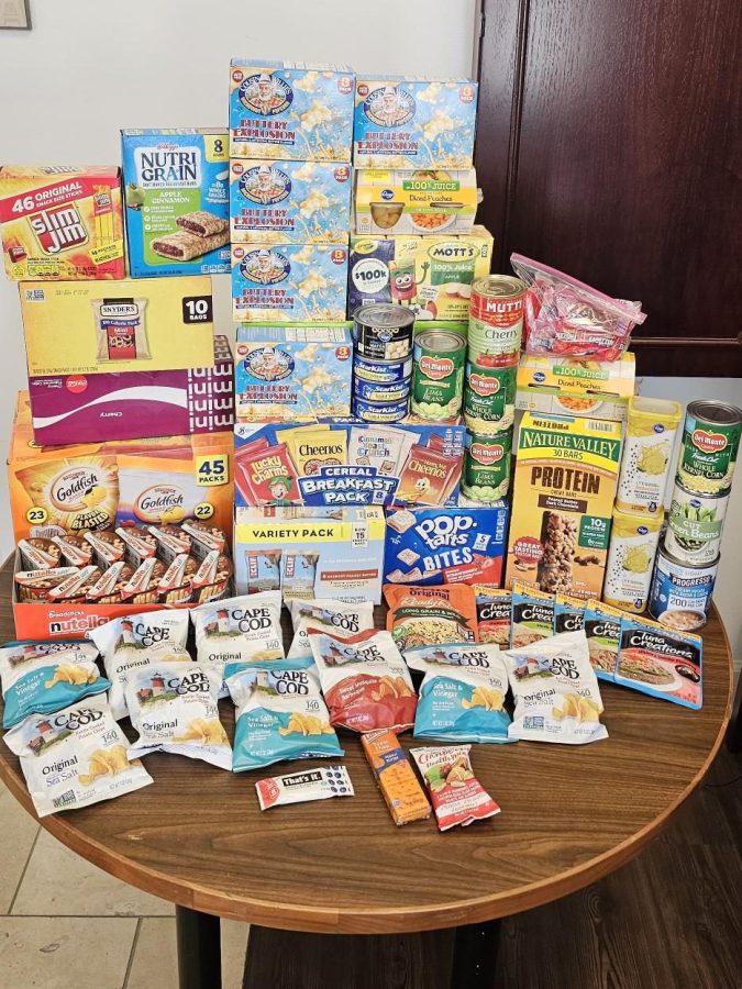 Food items piled on top of a wooden table.