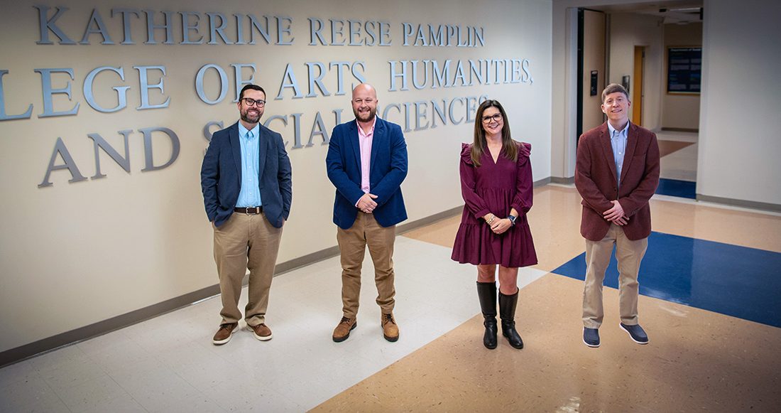 Three men and a woman standing for a photo