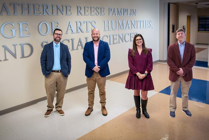 Three men and a woman standing for a photo