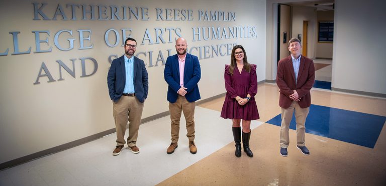 Three men and a woman standing for a photo