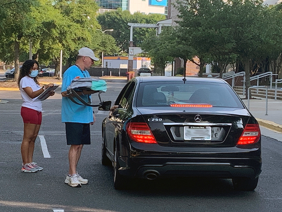 Man putting a backpack in a car