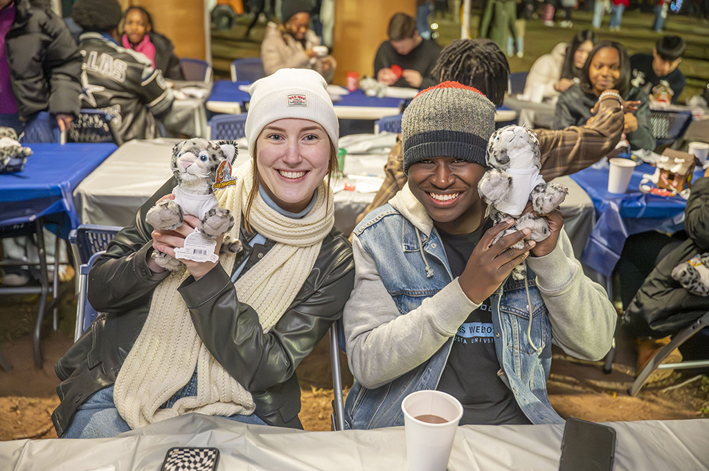 People holding a Jaguar plush toy