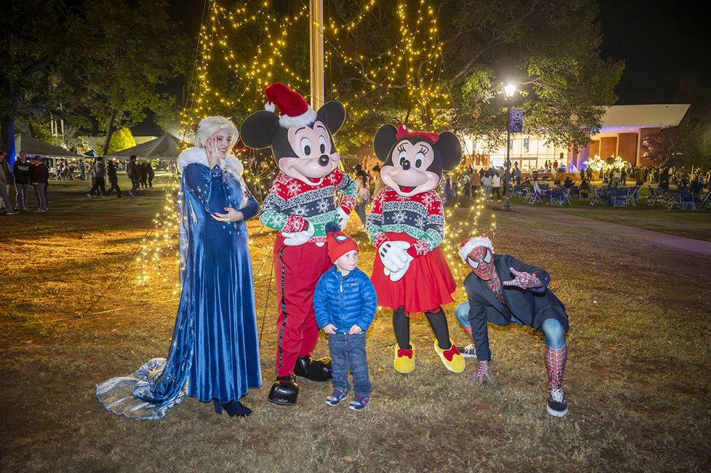 Child standing next to movie characters