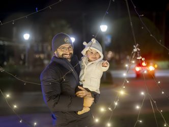 Man holding his daughter looking at lights