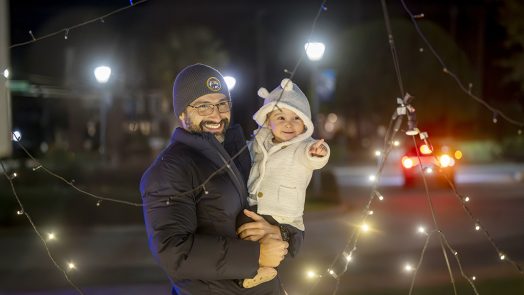 Man holding his daughter looking at lights