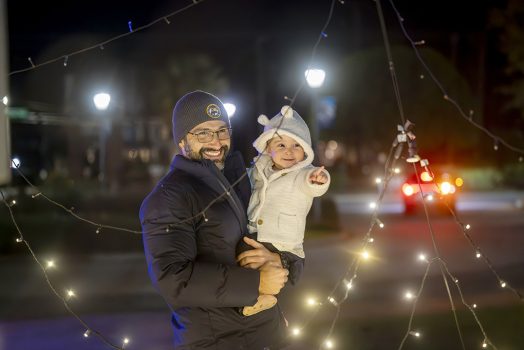 Man holding his daughter looking at lights