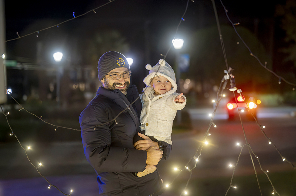 Man holding his daughter looking at lights