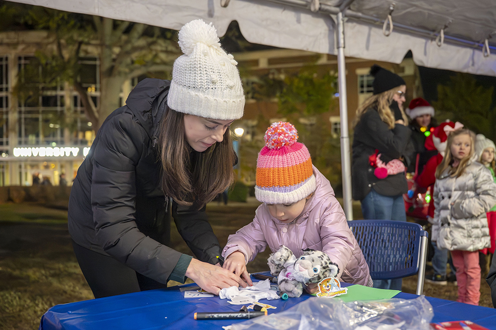 Woman helping a child with arts and crafts