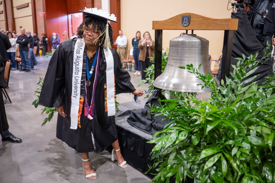 Female student rings silver bell. 