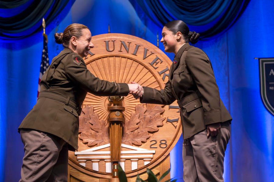 Two female officers shaking hands. 