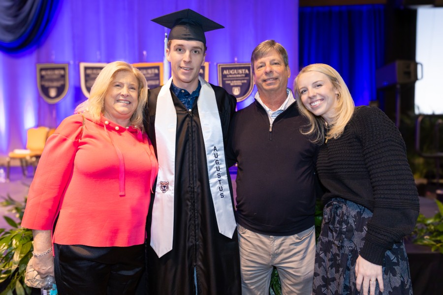 Two men and two women standing together and smiling.