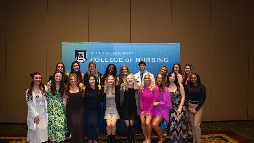 Athens students pose together in front of blue CON step-and-repeat