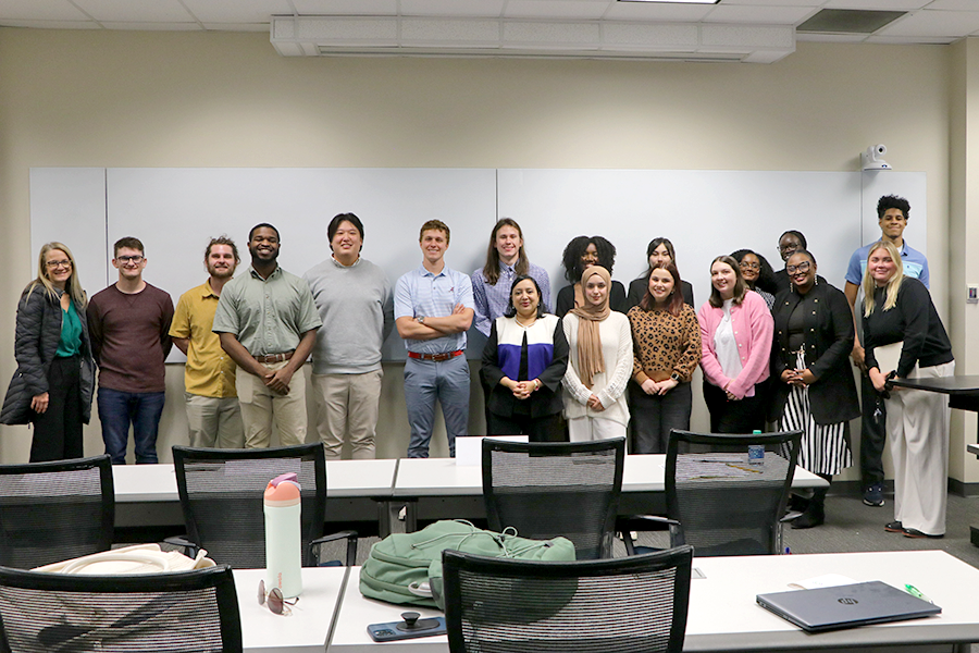 A group of college students take part in a service learning experience in a classroom setting.